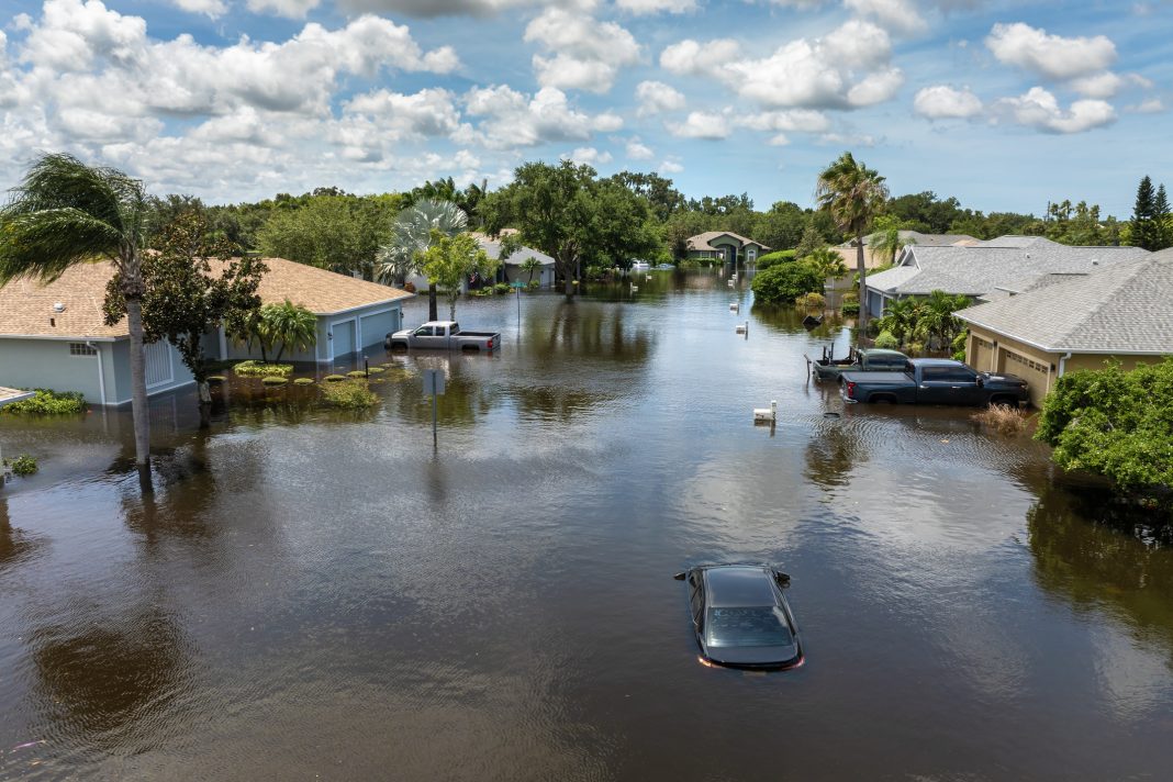 Hurricane rainfall flooded road. Drowned car on city street in Florida residential area. Consequences of hurricane natural disaster.