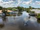 Hurricane rainfall flooded road. Drowned car on city street in Florida residential area. Consequences of hurricane natural disaster.