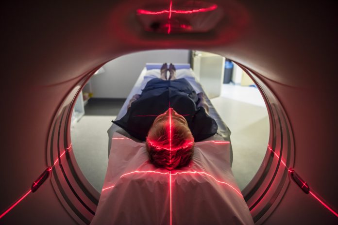 Patient lying inside a medical scanner in hospital