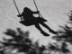 Blurry shadows of girl on a swing and a tree branch