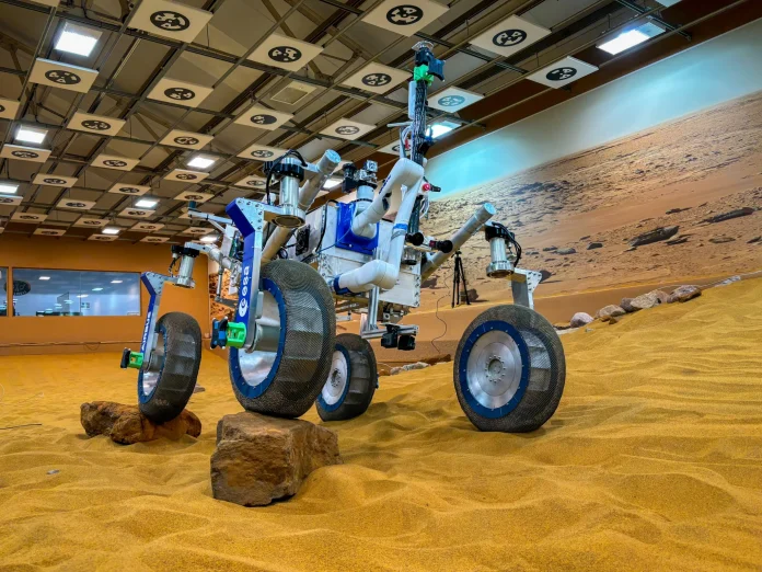 A test rover with shape memory alloy spring tires traverses rocky, Martian-simulated terrain. Credit © NASA