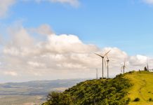 Scenic View Of Landscape And Wind Turbines Against Sky