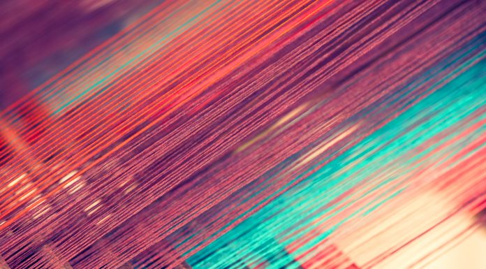 Multicolored straight strands texture background, sewing equipment, loom equipment at a garment factory