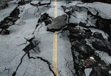 Suburban road washed out by flash flooding from record-breaking rainfall.