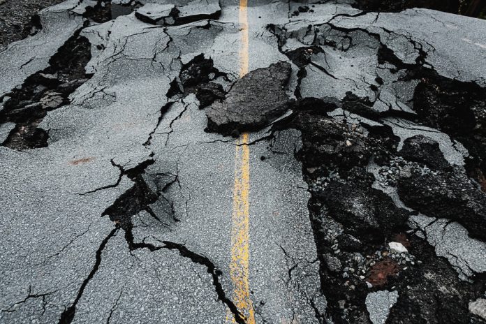 Suburban road washed out by flash flooding from record-breaking rainfall.