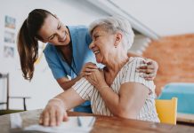 Home care healthcare professional hugging senior patient