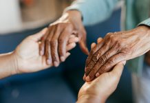 Young woman holding elderly hands