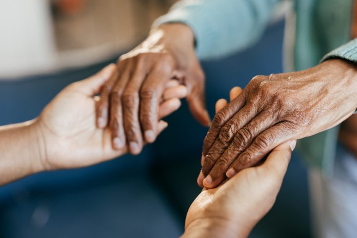 Young woman holding elderly hands