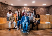 Portrait of a wheelchair businessman and coworkers during presentation at office