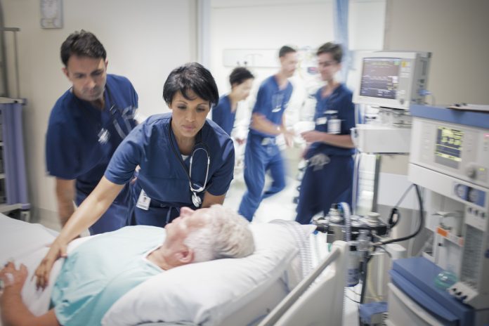 Two doctors preparing elderly patient before medical procedure