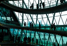 Abstract modern architecture and silhouettes of people on spiral staircase